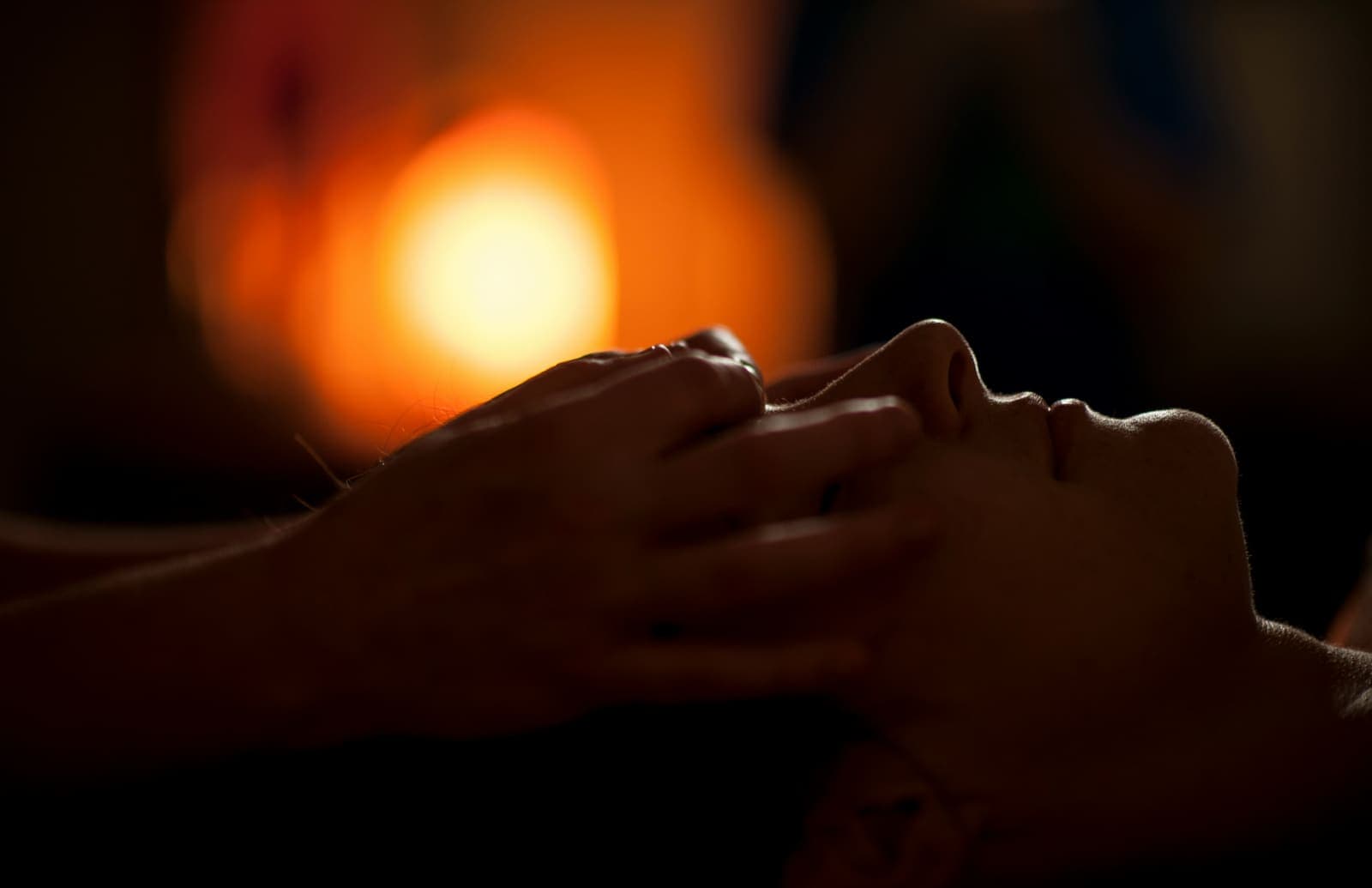 A guest receiving a facial treatment by candlelight