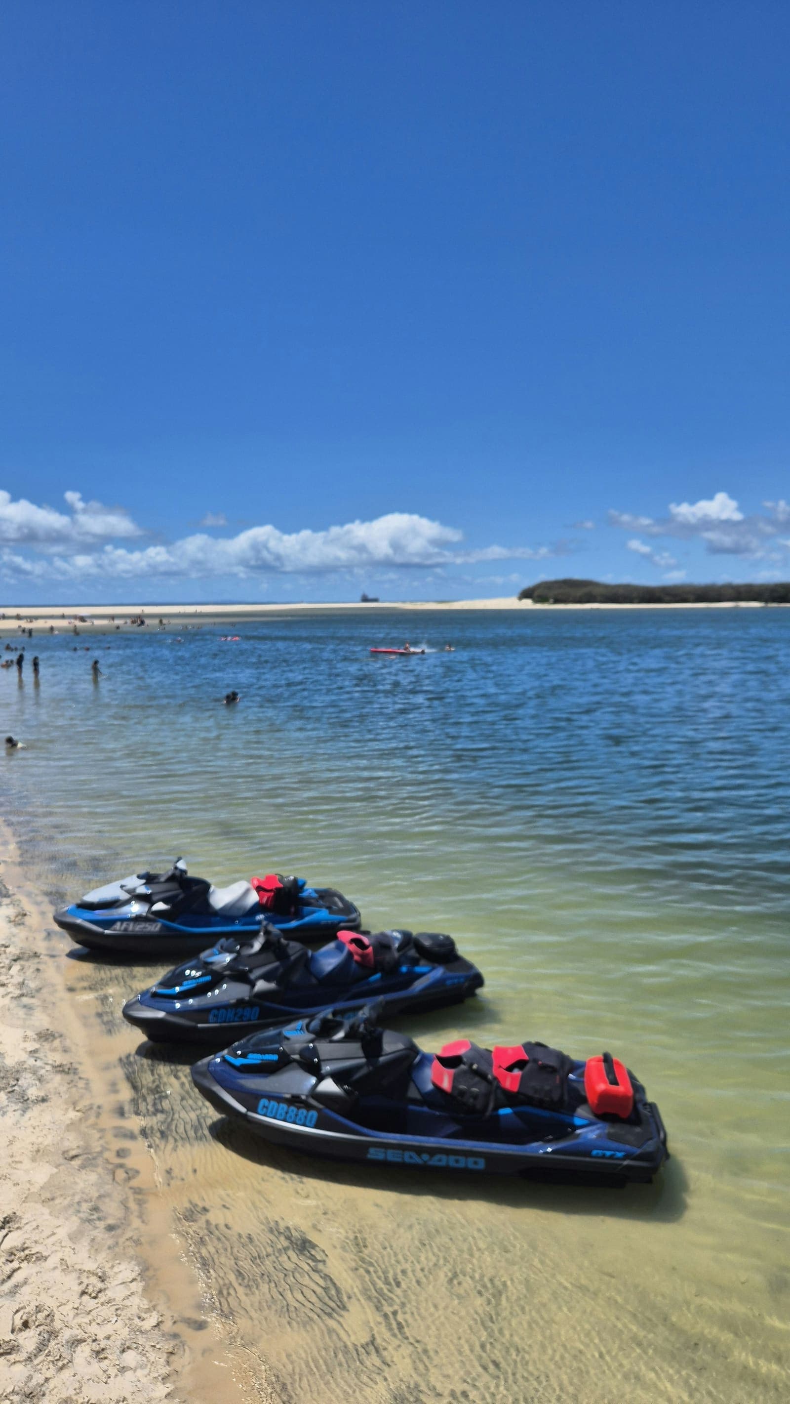 Jet skis pulled up on a beach, ready for a guest watersports session